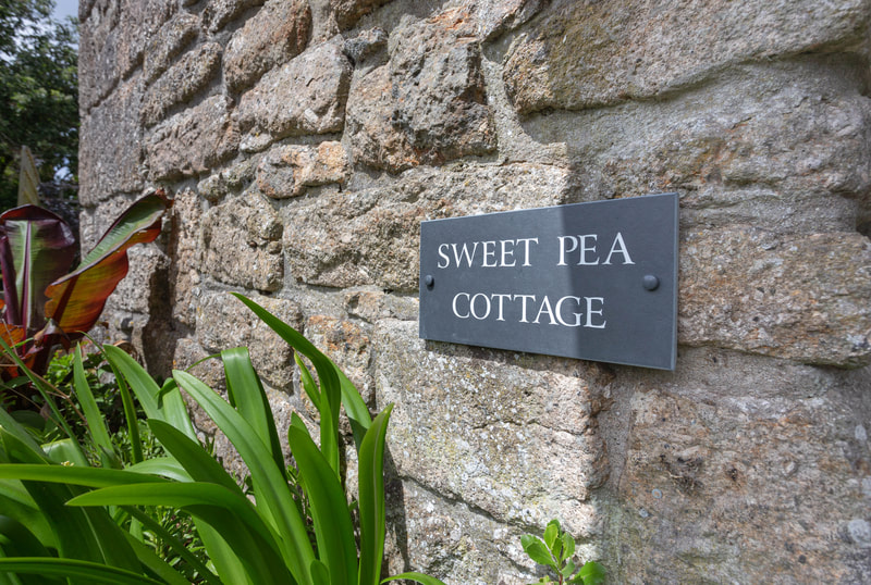 Cottage exterior front door sign of Sweet Pea holiday cottage in Penzance Cornwall