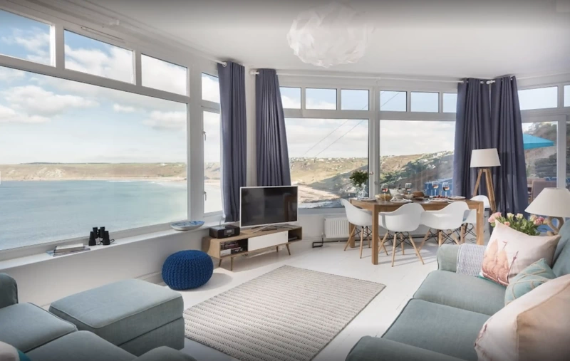 living area space with sea views out of windows of a holiday apartment to let in Sennen Cove Cornwall